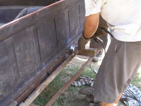 1969 Ford F-250 - Repairing the bed of an old truck with a welder. The metal shows signs of rust and wear.