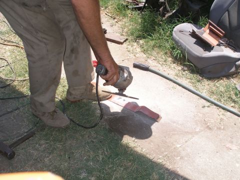 1969 Ford F-250 - Grinding a metal part with an angle grinder, with a car seat visible nearby.