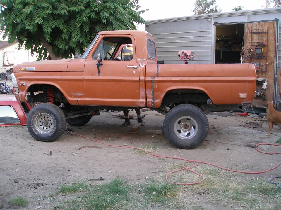 Orange pickup truck with lifted suspension and custom bodywork