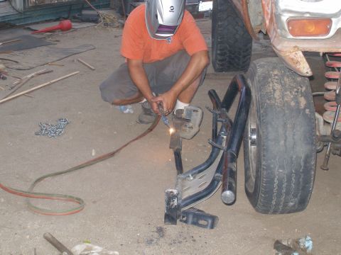 1969 Ford F-250 - A person is welding a part of a vehicle's frame while wearing a welding mask.