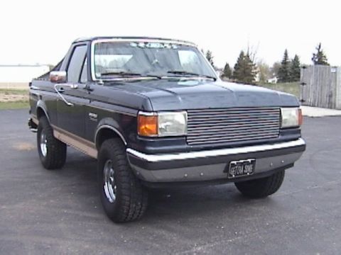 1995 Ford Bronco - This 1995 Ford Bronco is shown from a 3/4 front angle, a dark blue exterior with a tan stripe.