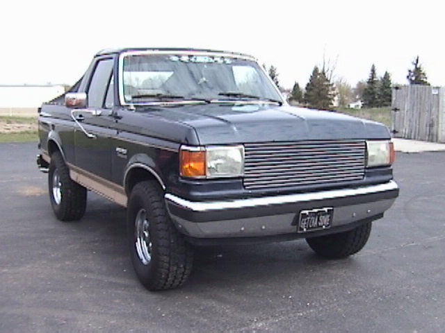 1995 Ford Bronco, dark blue with tan stripe, 3/4 front view