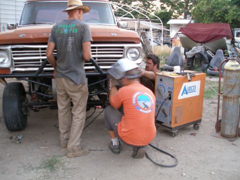 1969 Ford F-250 - Workers are welding a custom bumper onto a truck, with a welding machine nearby.