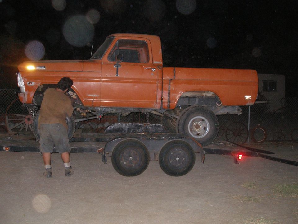 Orange 1969 Ford F-250 pickup truck on a trailer, side view