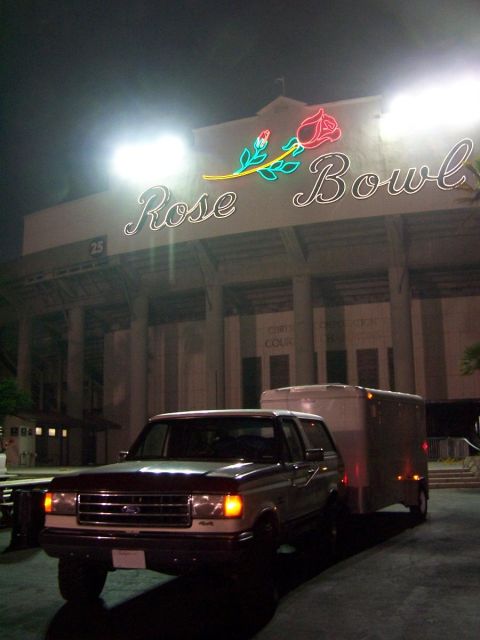 1990 Ford Bronco - A 1990 Ford Bronco tows a trailer in front of the iconic Rose Bowl stadium at night.