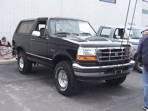 1995 Ford Bronco - A black Ford Bronco is parked next to another vehicle.