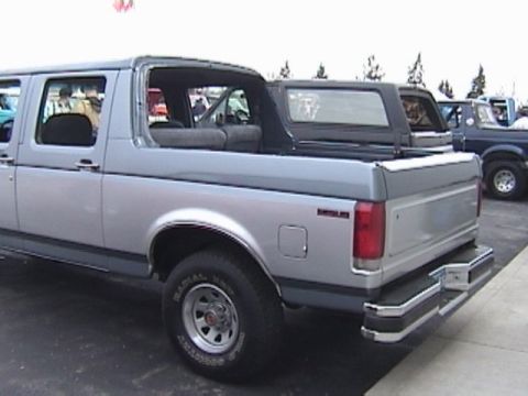 1995 Ford Bronco - Rear view of a two-tone silver and gray 1995 Ford Bronco, parked outdoors.