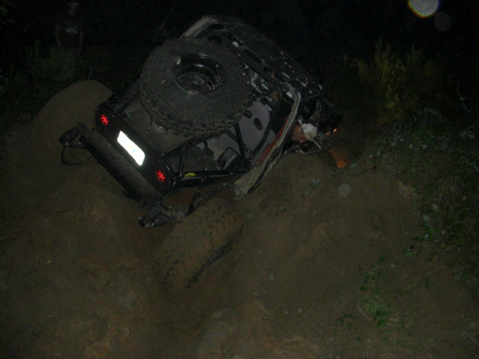 Off-road vehicle tilted on its side with a spare tire mounted on top