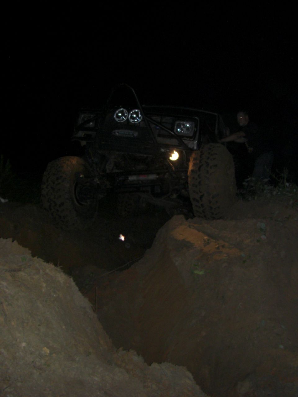 Off-road vehicle with auxiliary lights driving on dirt at night