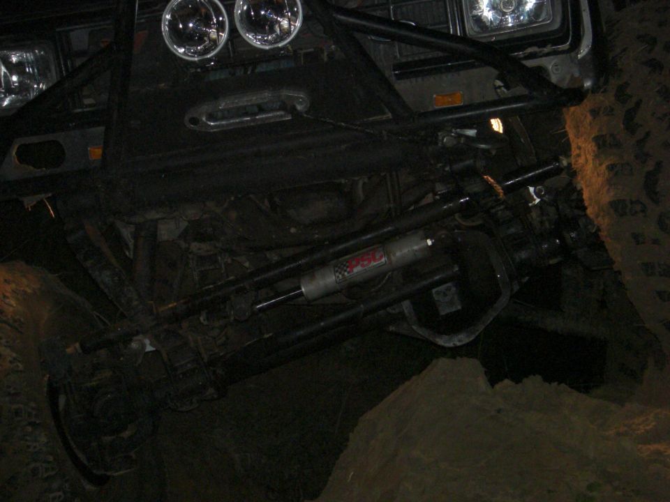 Off-road vehicle front end with winch, aftermarket bumper, and suspension components visible
