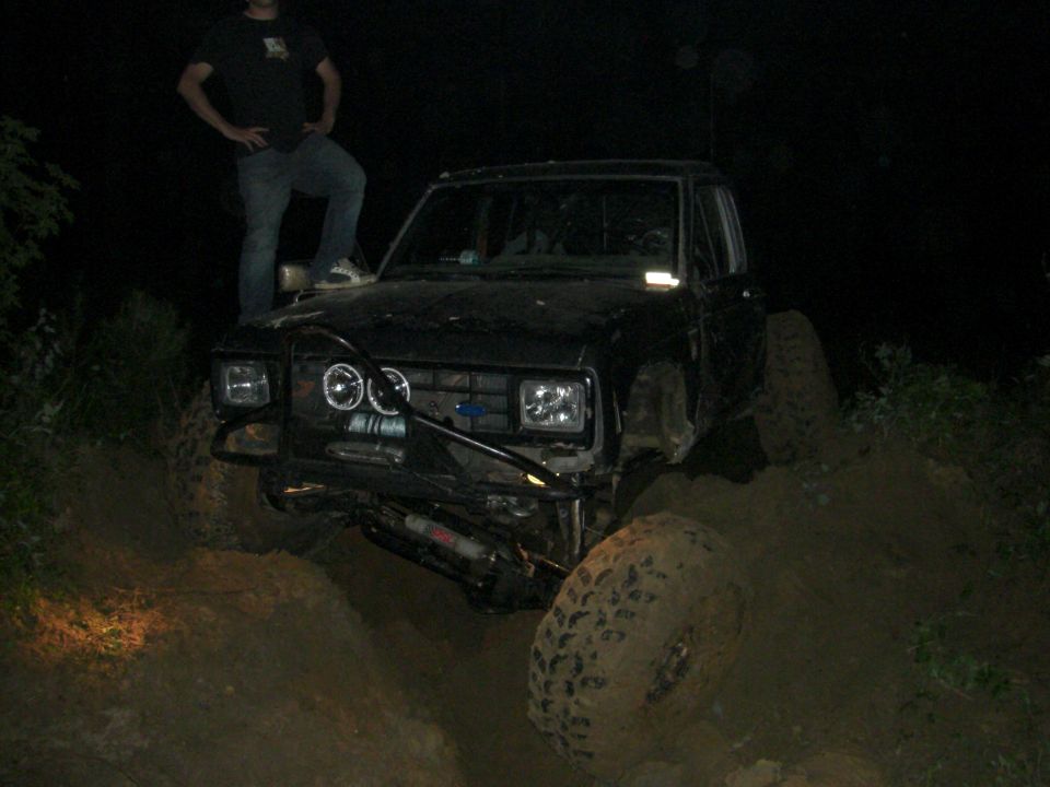 1984 Ford Bronco II with aftermarket bumper and winch, off-roading at night