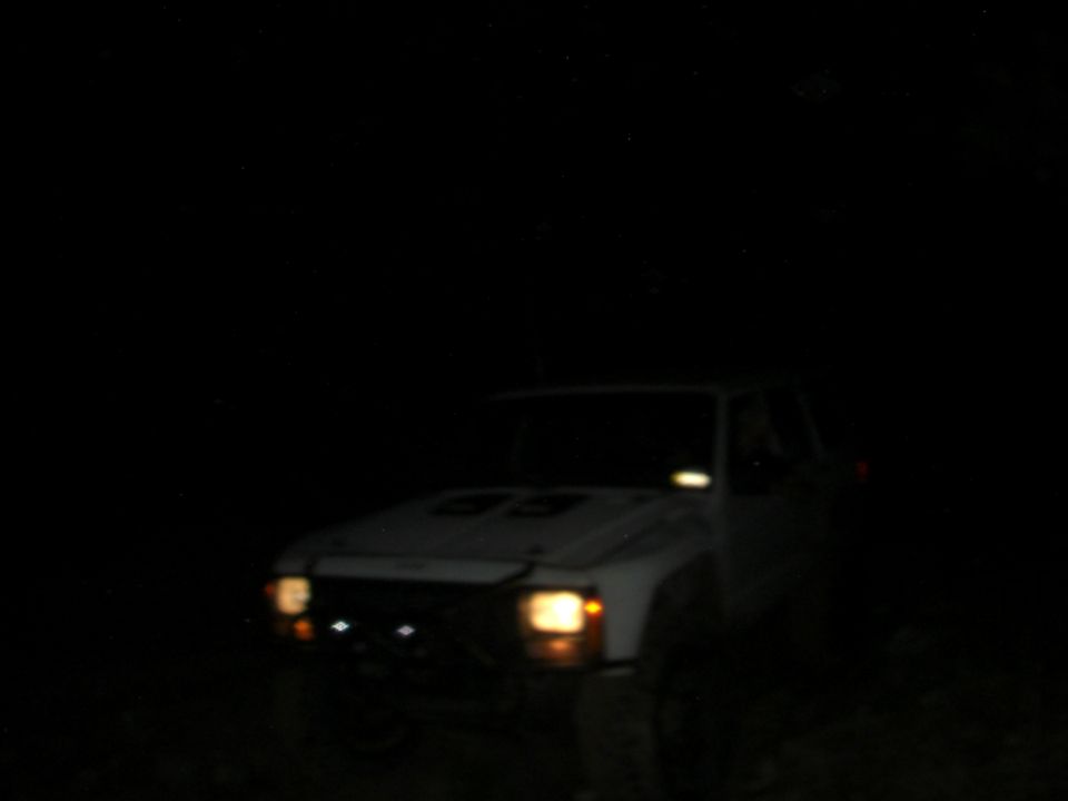 White 1984 Ford Bronco II with hood scoops at night
