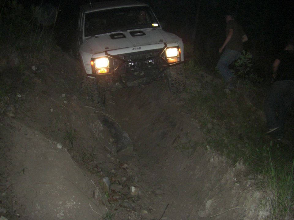 White Jeep Cherokee XJ driving off-road at night