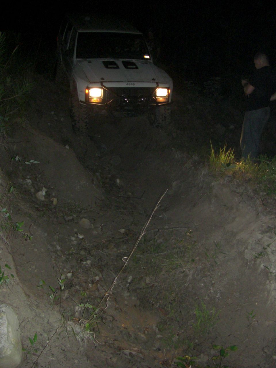 White SUV driving off-road at night