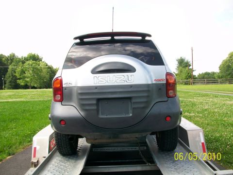 1999 Isuzu Vehicross - Rear view of a silver Isuzu Vehicross on a trailer, showing its distinctive spare tire cover and 4WD badging.