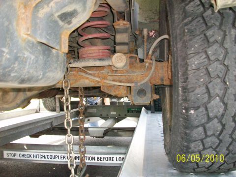 1999 Isuzu Vehicross - Close-up of a vehicle's rear suspension and tire while being loaded onto a trailer.