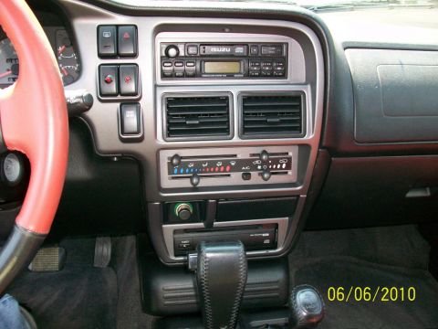 1999 Isuzu Vehicross - Interior view of a vehicle's dashboard, a red steering wheel and an Isuzu branded radio.