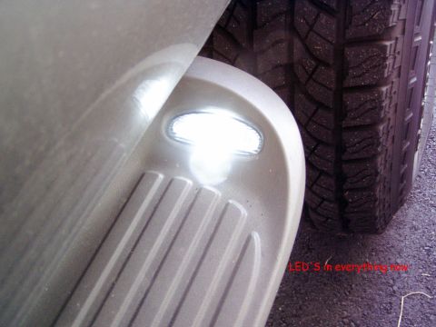 2001 Ford Excursion - Close-up of a vehicle's running board an LED light, positioned next to a tire. Text overlay reads 'LED'S in everything now'.