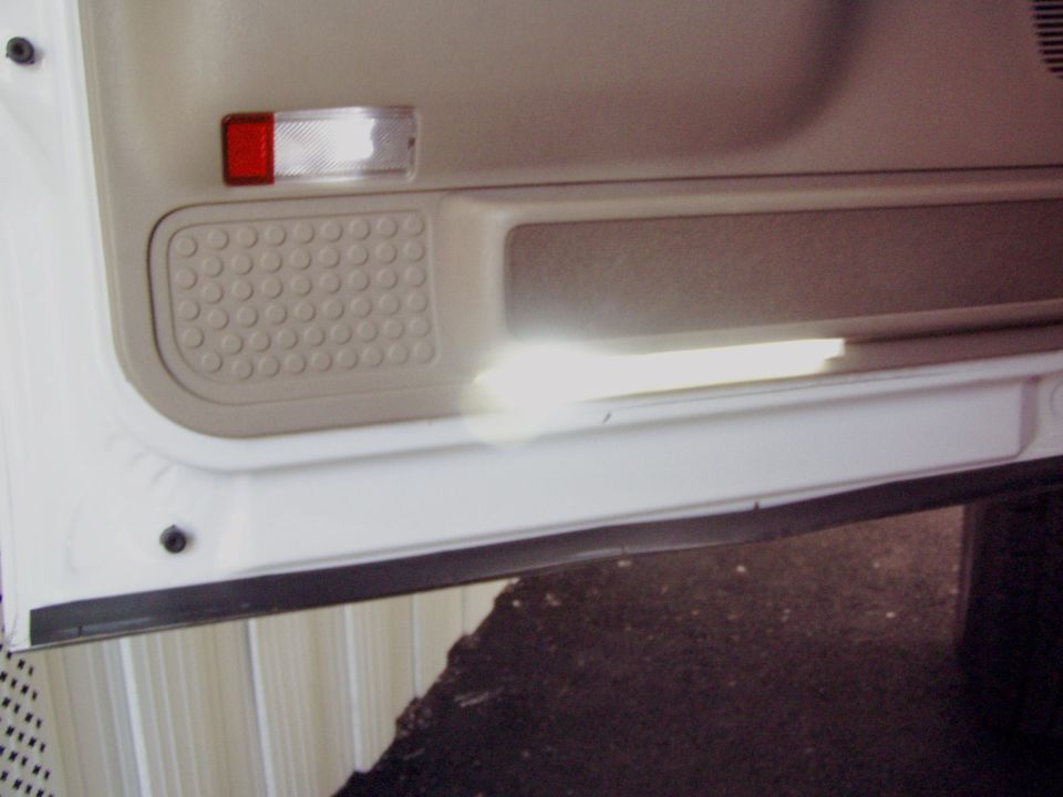 Interior door panel with a red and clear reflector and a textured speaker grille