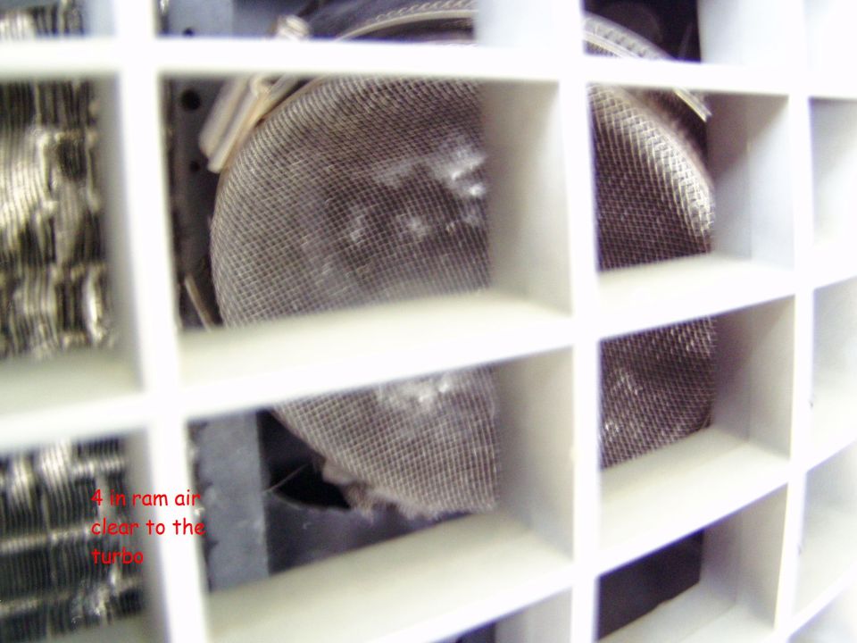 Close-up of a white grille with mesh screens behind it, possibly for air intake