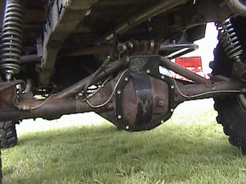 1995 Ford Bronco - Close-up view of the undercarriage, focusing on the rear axle and suspension system of an off-road vehicle.
