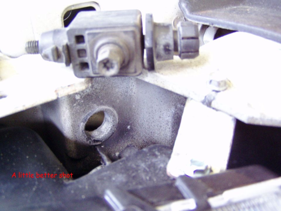Close-up of a mechanical part with a screw head and a hole