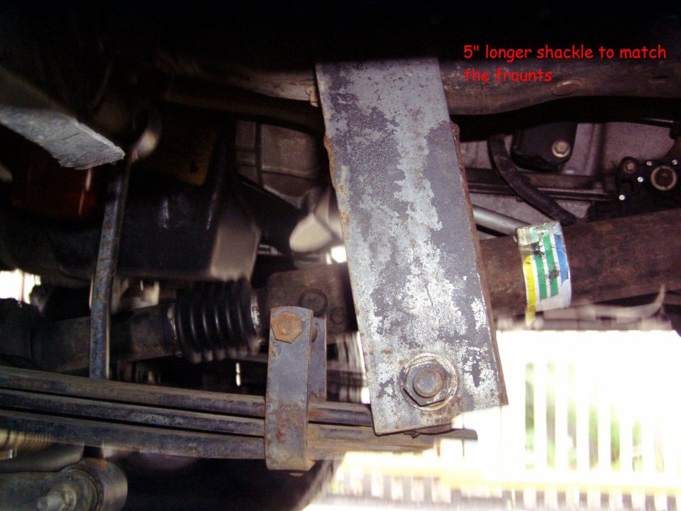 Underbody view of a longer shackle attached to leaf springs