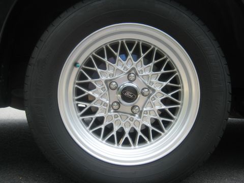 1999 Ford Crown Victoria - A close-up view of a silver mesh wheel with a Ford logo on the center cap.