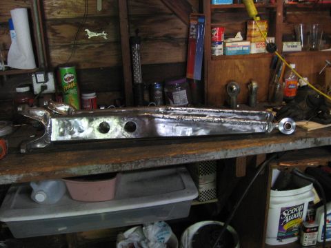 1989 Ford Bronco - A heavily modified axle housing sits on a workbench, likely awaiting further modification or installation.