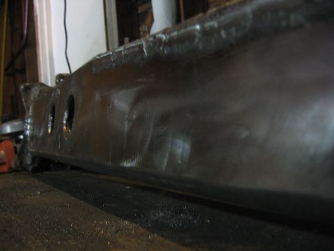 1989 Ford Bronco - A dark metal component with three visible holes is shown in this close-up view.