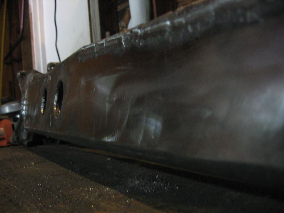Close-up of a dark metal part with three circular holes