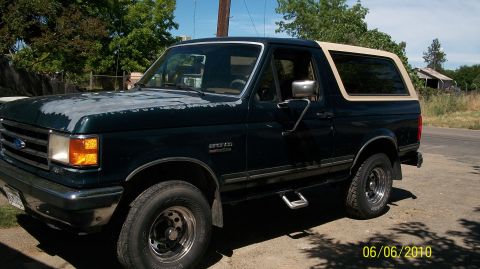 1991 Ford Bronco - This 1991 Ford Bronco is seen in a 3/4 front view, a dark green body and a tan removable top.