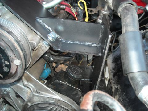 1985 Ford Bronco - A custom metal bracket is installed in the engine bay, connecting to various engine components.