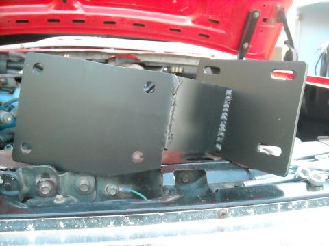 1985 Ford Bronco - Custom metal brackets are shown installed under the hood of a vehicle.