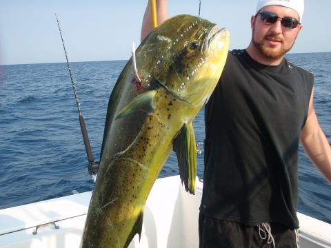 1995 Ford Bronco - A man proudly displays a large mahi-mahi caught while fishing from a boat.