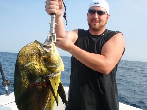 1995 Ford Bronco - A man proudly displays a large mahi-mahi fish he caught while out on the water.