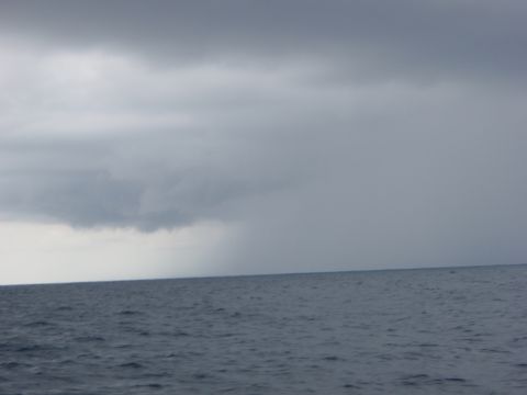 1995 Ford Bronco - A dark, stormy sky looms over the choppy ocean waters, suggesting an approaching storm.