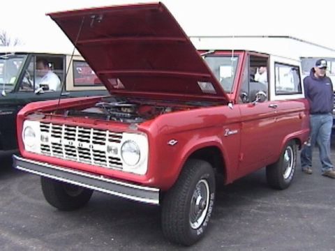 1995 Ford Bronco - A red 1978 Ford Bronco is displayed with its hood open, alongside another vehicle.