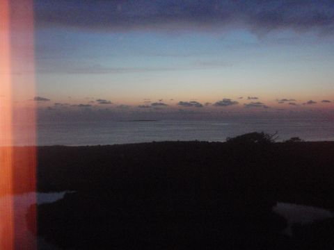 1995 Ford Bronco - The sky displays a gradient of colors during a coastal sunset, with dark land in the foreground.