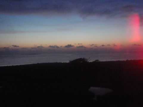 1995 Ford Bronco - Sunset over the ocean with clouds and a distant island.