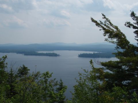 1995 Ford Bronco - A scenic view of a large body of water surrounded by forested islands and hills under a cloudy sky.