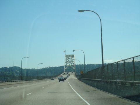 1992 Ford Bronco - A view from a vehicle driving on a highway towards a large bridge, with other cars on the road.