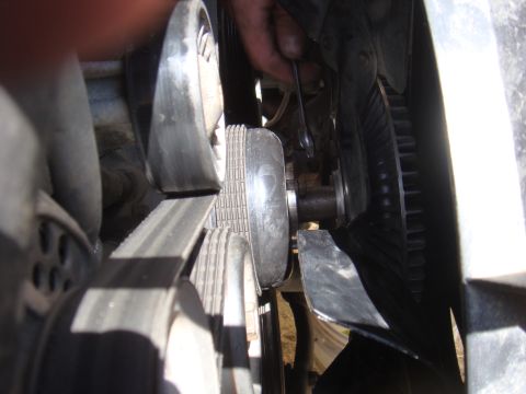 1992 Ford Bronco - Mechanic works on engine belt and fan assembly, likely for maintenance or repair.