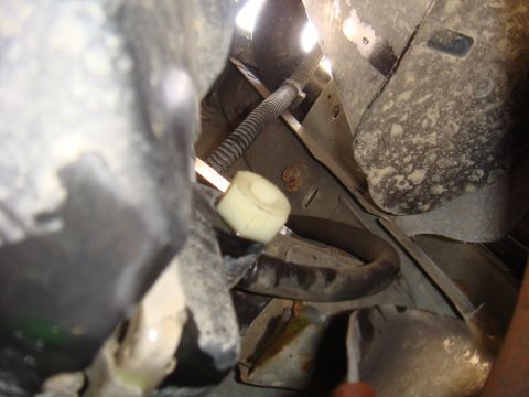 1992 Ford Bronco - Close-up view of vehicle undercarriage components, including a hose and a plastic fitting.
