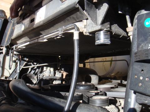 1992 Ford Bronco - Close-up view of an engine bay, focusing on the radiator, hoses, and various belts and pulleys.