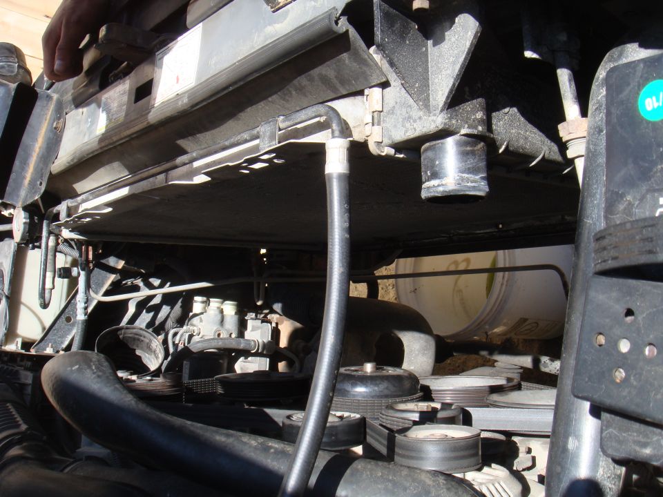 Engine bay view showing radiator, hoses, and belts