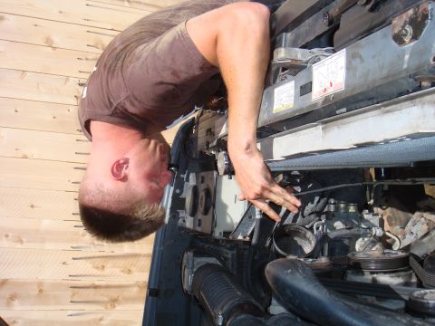 1992 Ford Bronco - A mechanic is seen working on the engine of a vehicle, with the Supermotors.net logo visible in the lower right corner.