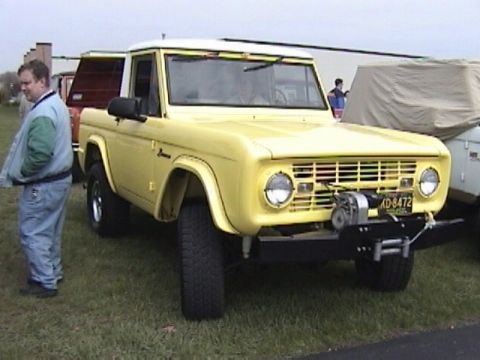 1995 Ford Bronco - This yellow Ford Bronco features a front-mounted winch and a visible license plate.