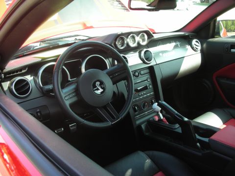 1992 Ford Crown Victoria - The interior of a car shows a Shelby Cobra emblem on the steering wheel and a manual transmission shifter.