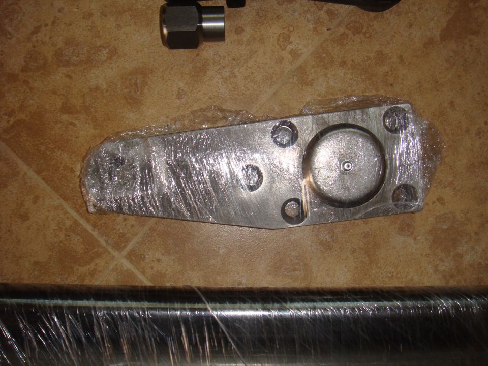 Metal part wrapped in plastic, with a bolt and nut nearby